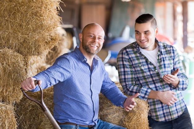 Dos agricultores que trabajan en el granero