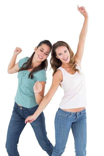 Dos alegres jóvenes amigas bailando