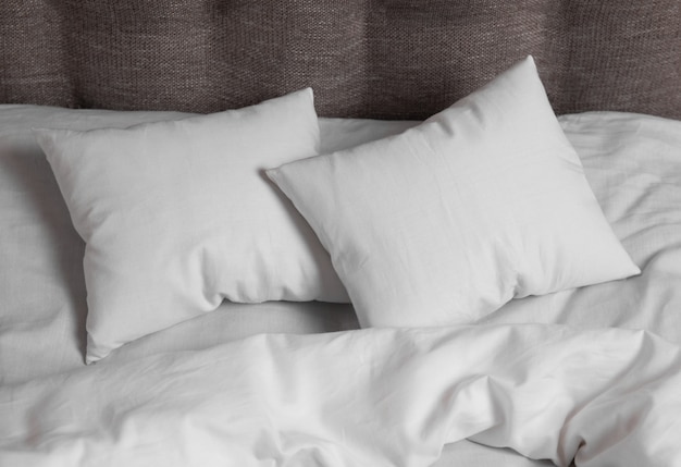 Foto dos almohadas blancas en la cama