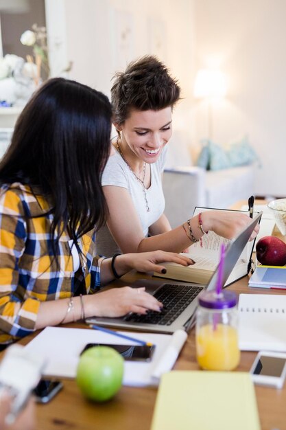 Foto dos alumnas trabajando juntas en la mesa en casa