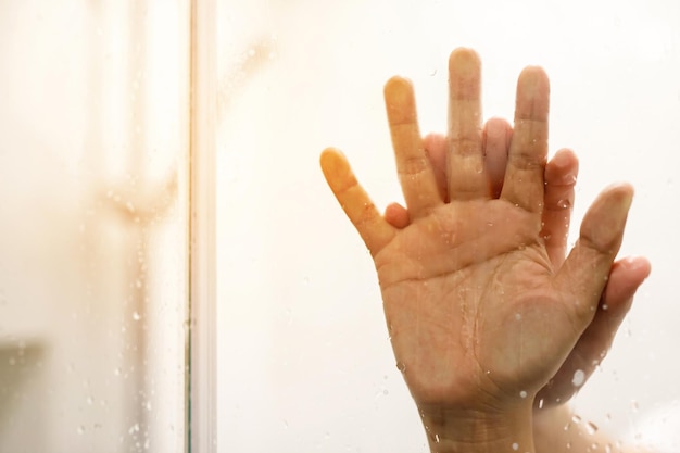 Dos amantes de la pareja masculina y femenina tomándose de la mano teniendo sexo dentro del espejo del baño de la ducha con un enfoque suave de la ventana humeante Deje el espacio de copia vacío para escribir texto en el costado