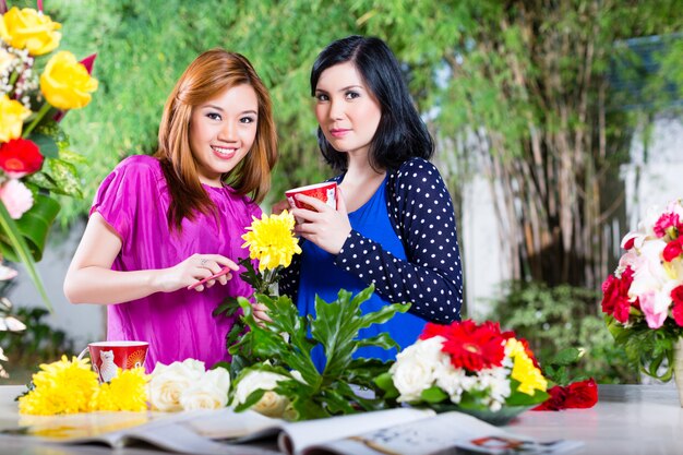 Dos amigas asiáticas con flores.