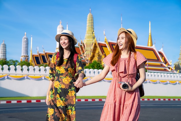 Dos amigas asiáticas viajan y toman fotos en el Gran Palacio y Wat phra kaew