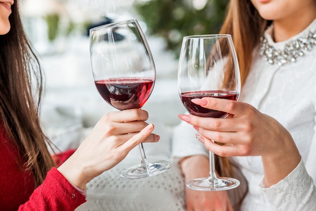 Dos amigas beben vino tinto en un restaurante