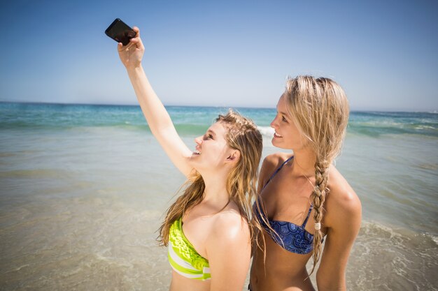 Dos amigas en bikini tomando una selfie