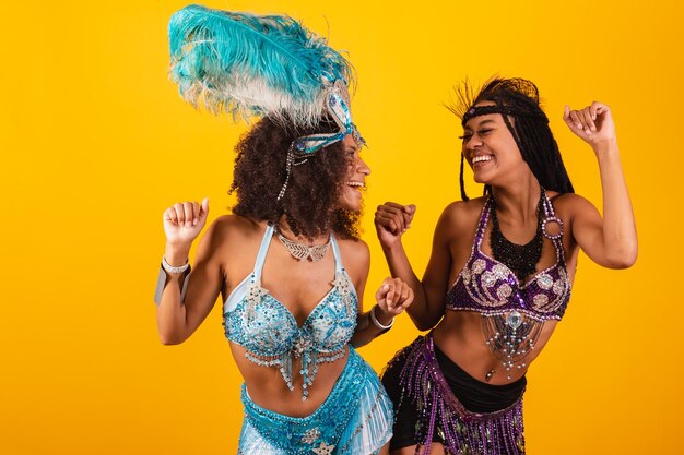 Dos amigas brasileñas en ropa de carnaval gritando promoción