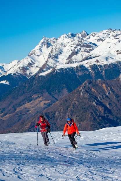 Dos amigas durante una caminata de montañismo en la nieve.