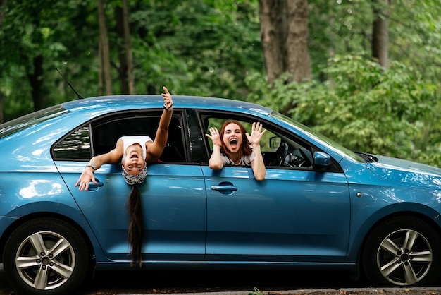 Dos amigas se divierten y se ríen juntas en un auto