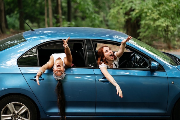 Foto dos amigas se divierten y se ríen juntas en un auto