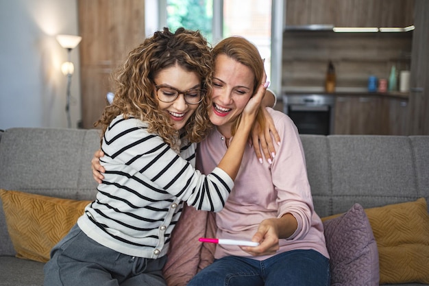 Dos amigas están emocionadas por los resultados de una prueba de embarazo.