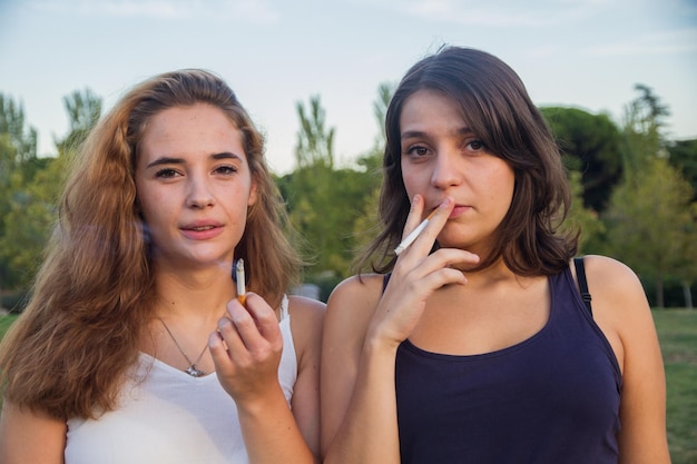 Dos amigas fumando en el parque