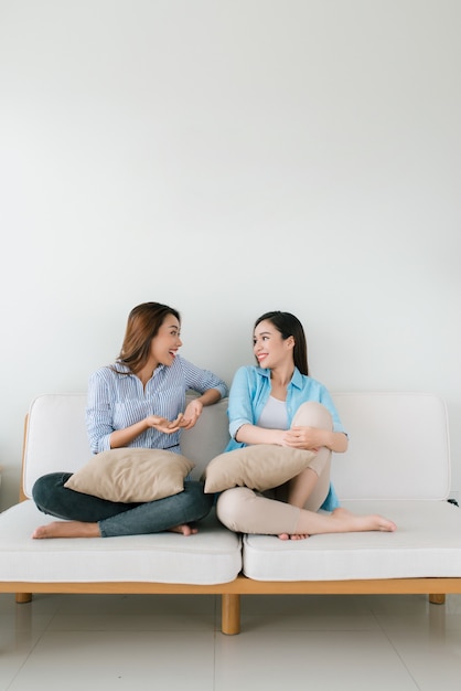 Dos amigas hablando en el sofá de casa