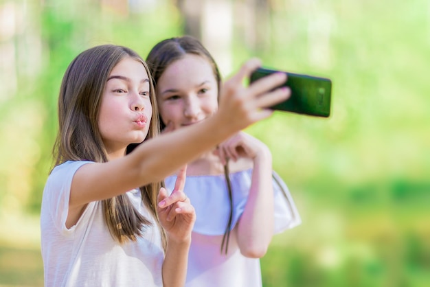 Dos amigas hacen selfie en el bosque Día soleado de verano