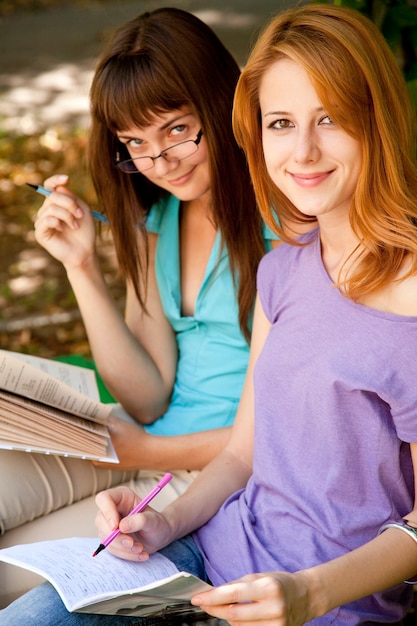 Dos amigas haciendo los deberes en el parque.