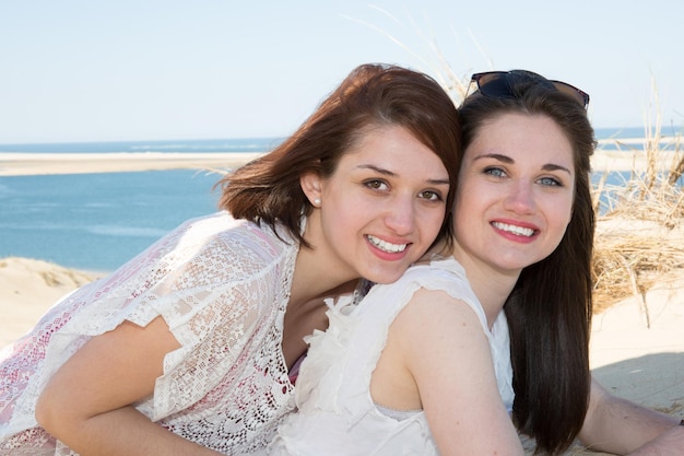 Dos amigas jóvenes atractivas de pie juntas y posando en la cámara