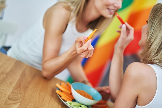 Dos amigas jóvenes comiendo alimentos saludables