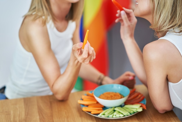 Dos amigas jóvenes comiendo alimentos saludables