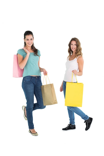 Dos amigas jóvenes felices con bolsas de compras