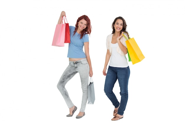 Dos amigas jóvenes felices con bolsas de compras