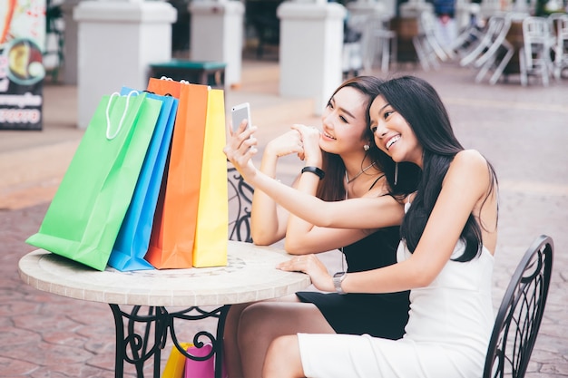 Dos amigas jóvenes felices toman foto selfie por teléfono inteligente