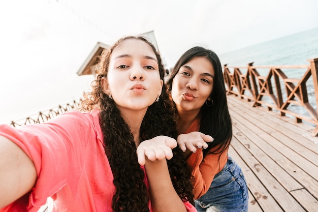 Dos amigas latinas lanzando un beso y tomándose una foto en un lugar turístico en Honduras