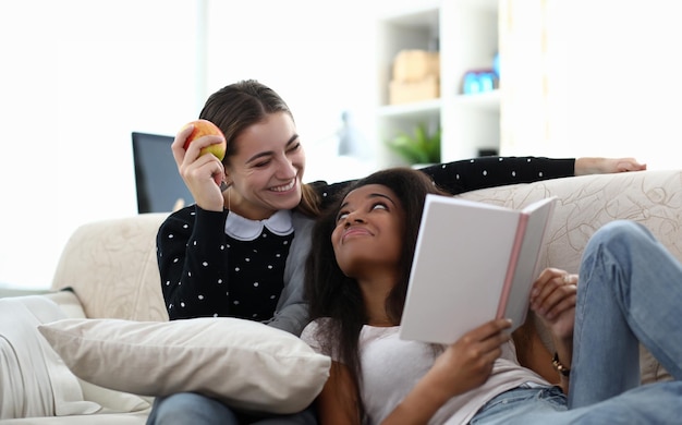 Dos amigas leyendo libros sentadas en el vagón contra