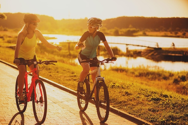 Dos amigas montando en bicicleta al atardecer