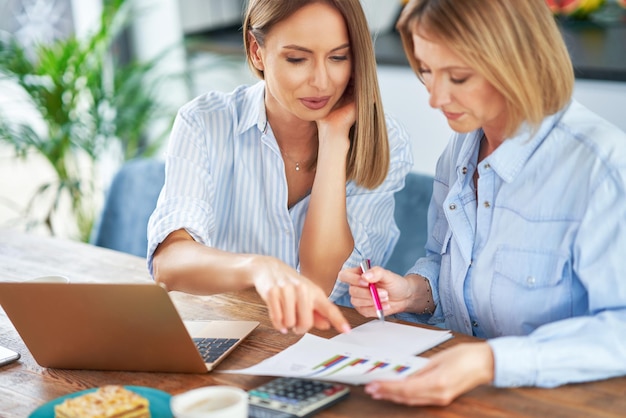 Dos amigas o pareja lgbt con computadora y factura.