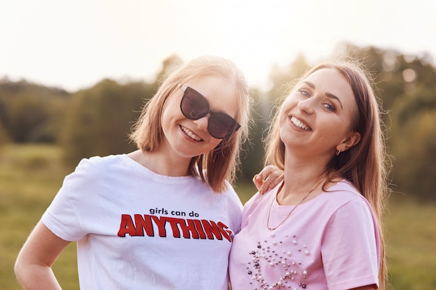 Dos amigas positivas usan camiseta y sombras