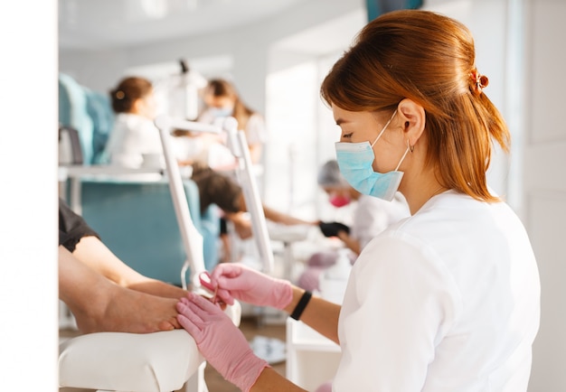 Dos amigas, proceso de pedicura en salón de belleza