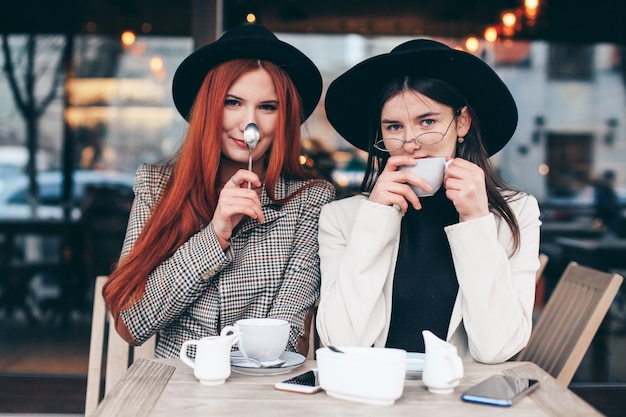 Dos amigas tomando café en la cafetería