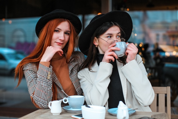 Dos amigas tomando café en la cafetería