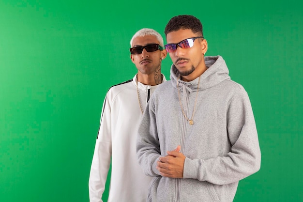 Dos amigos adultos jóvenes estilo hip hop con fondo verde ideal para recortar