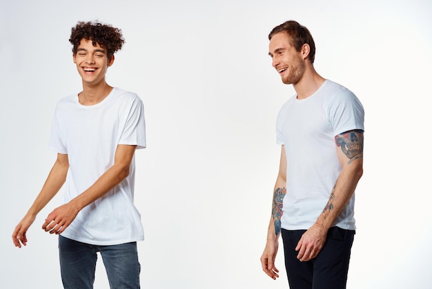 Dos amigos alegres en camisetas blancas alegría fondo de luz positiva foto de alta calidad