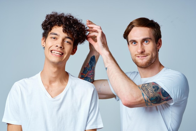 Dos amigos alegres en camisetas blancas estudio de emociones