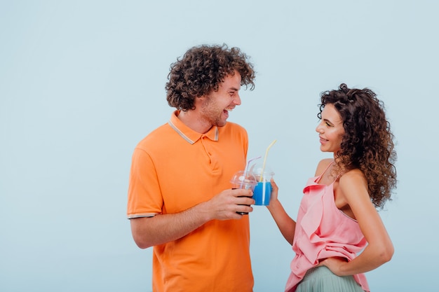 Dos amigos beben jugo del vaso de plástico