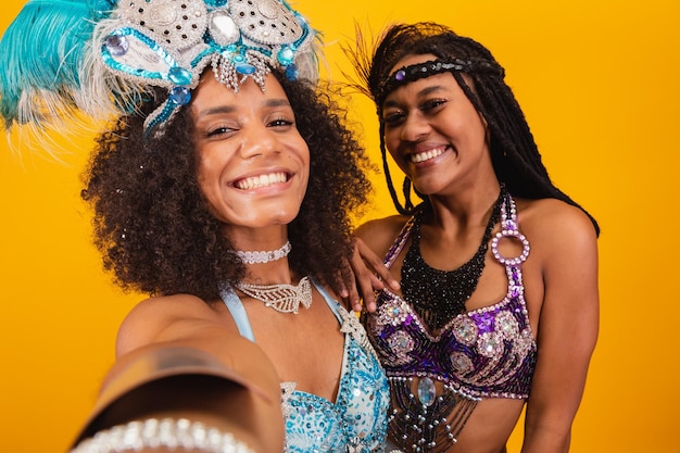 Dos amigos brasileños en ropa de carnaval tomando autorretrato con teléfono inteligente