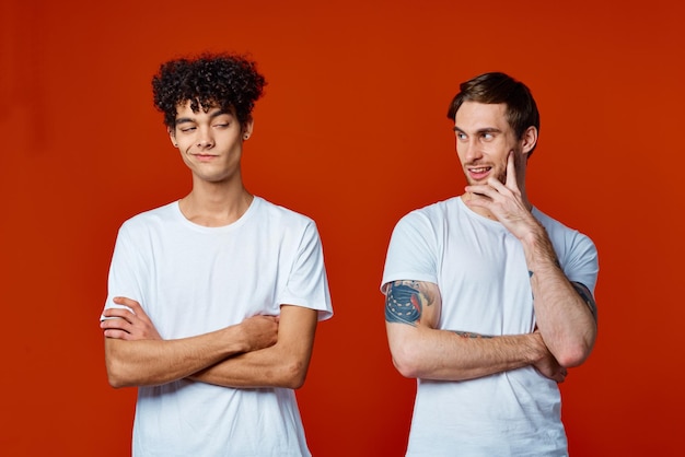 Dos amigos en camisetas blancas equipos de construcción él emociones fondo rojo