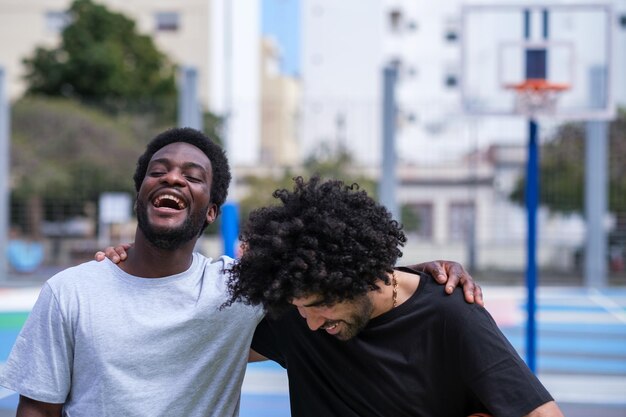 Dos amigos divirtiéndose juntos en una cancha urbana