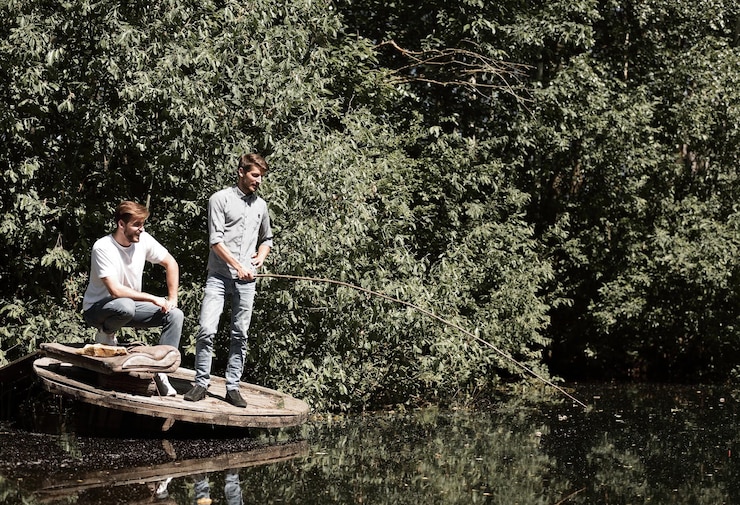 Foto dos amigos están pescando en el lago en el estilo de vida temprano en la mañana