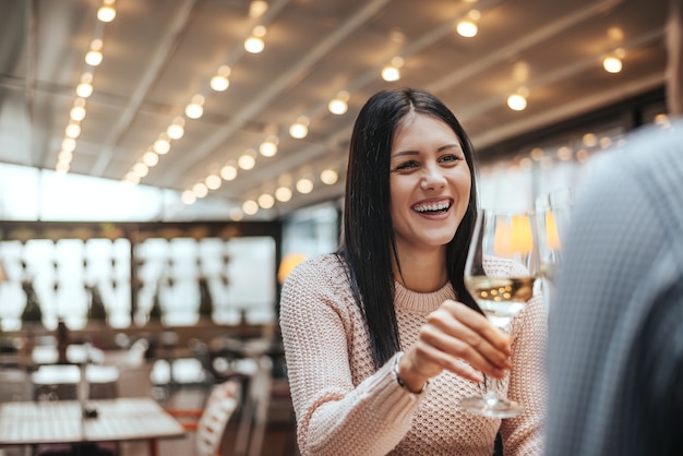 Dos amigos hablando y bebiendo vino en la cafetería restaurante.