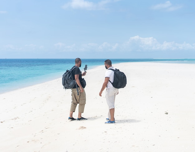 Dos amigos en la hermosa playa caliente