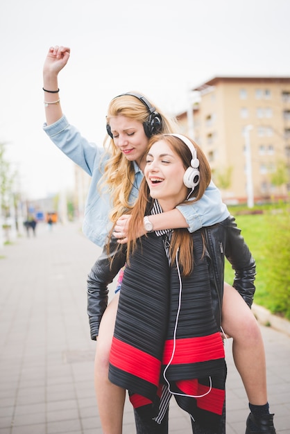 dos amigos hermosos chica escuchando música sonriendo