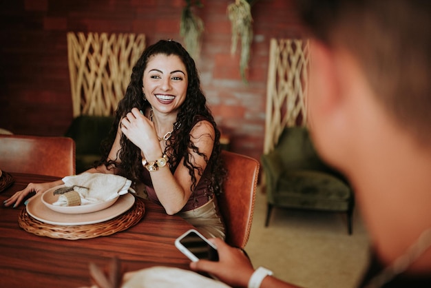 Dos amigos latinos reunidos alrededor de una mesa en un restaurante o en casa