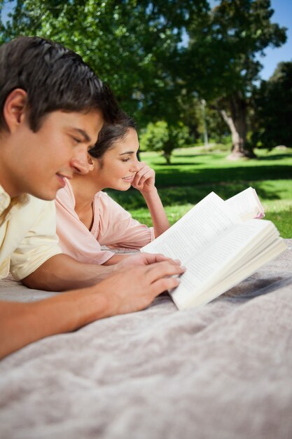 Dos amigos leyendo libros en un parque