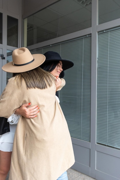 Dos amigos saludándose con un abrazo en la entrada de un edificio