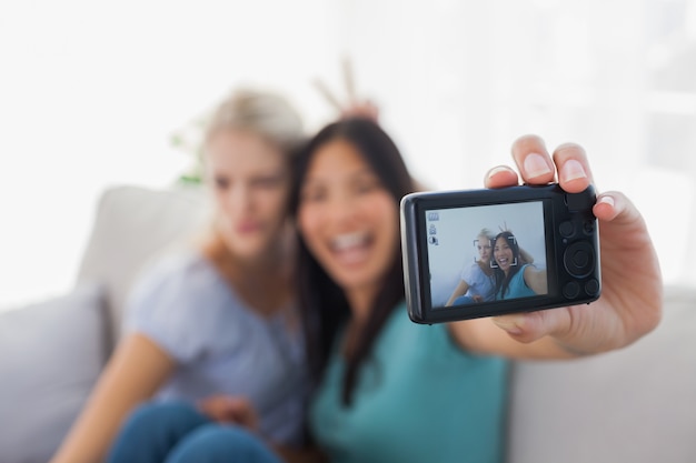 Foto dos amigos sonrientes que toman la foto con la cámara