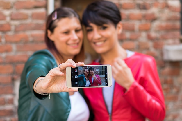 Dos amigos se toman un selfie en una calle urbana