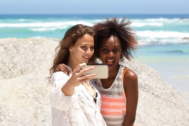 Dos amigos tomando selfie con teléfono móvil