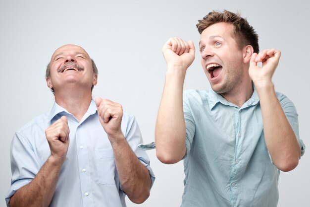 Dos amigos varones guapos bailando en la fiesta de cumpleaños